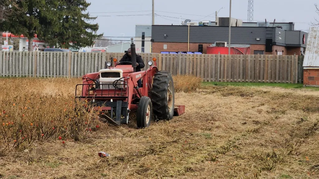 RESOLVEFARM farmer standing by a green tractor on the farm